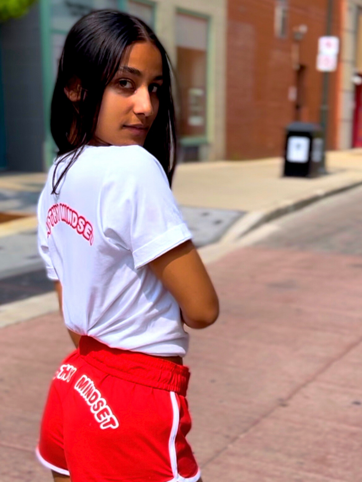 This stylish glow shorts set is designed for confident women who are determined to manifest success in every aspect of their lives. The white v-neck shirt and colored shorts front design features our brand name initials with our brand name in the back. The glow shorts are available in red, pink, navy and black.